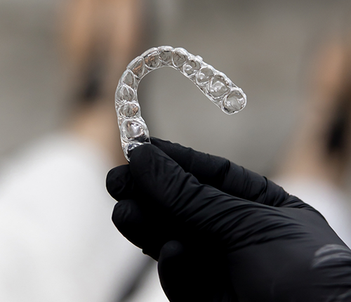 Orthodontist holding a clear aligner
