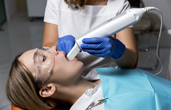 Dental professional taking digital scans of a patient's teeth