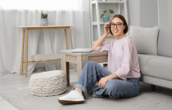 Smiling woman sitting on her living room floor