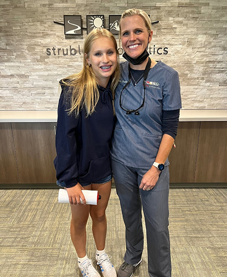 Doctor Struble smiling with a teenage girl with braces