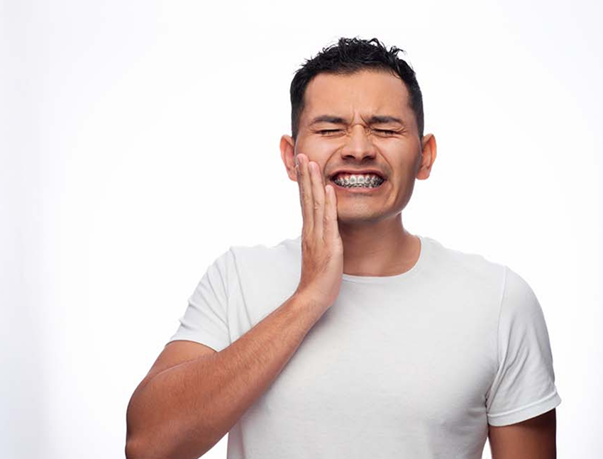 Teenage boy with braces in pain before seeing an emergency orthodontist in Bend