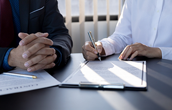 Two people filling out paperwork at a table