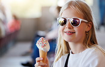 Girl with sunglasses holding an ice cream cone