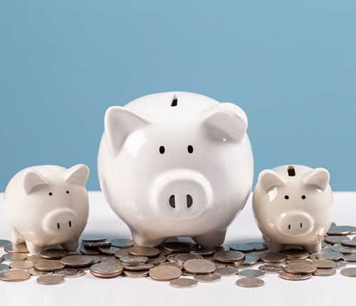 Three piggy banks on a pile of coins