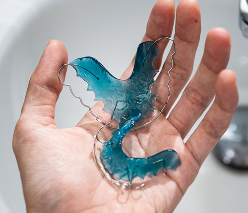 Hand holding two retainers