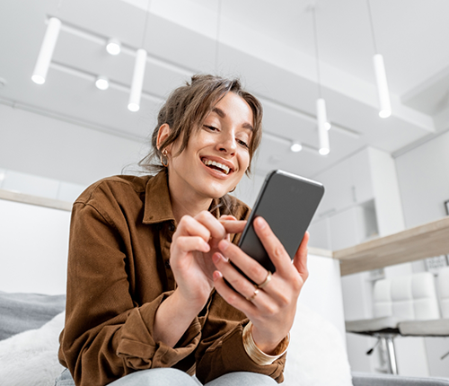 Woman smiling while looking at her phone
