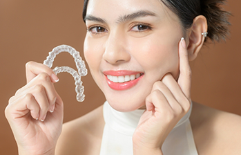 Woman holding two clear aligners
