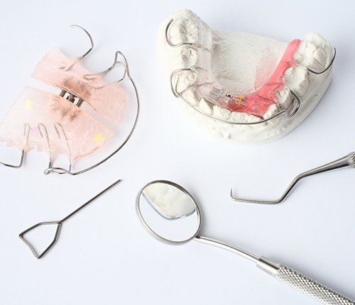 Two retainers next to dental instruments