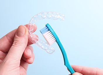 Patient cleaning clear aligner with toothbrush