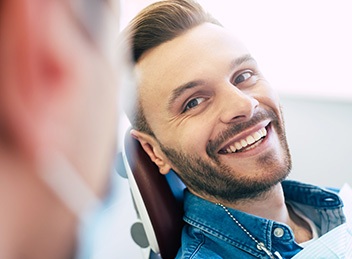 Man smiling while sitting in dentist's treatment chair