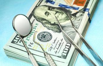 Dental instruments laying on top of hundred dollar bills
