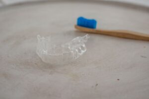 Clear aligner tray next to toothbrush